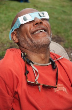Black man wearing eclipse glasses enjoying the phenomenon